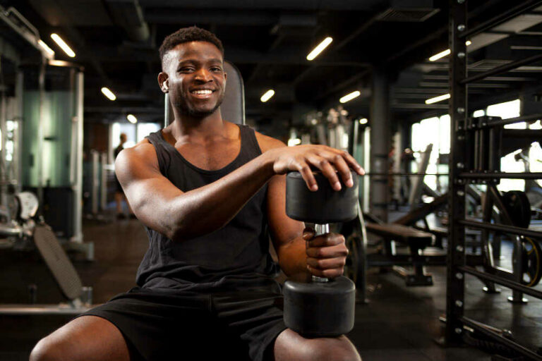 young-athletic-african-american-man-is-training-dark-gym-smiling-sports-guy-is-sitting